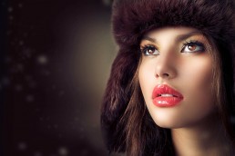 Beautiful-girl-wearing-a-brown-fur-hat-on-a-brown-background