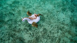 Girl-on-unicorn-pool-lounger-floating-in-the-shallow-sea
