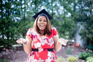 Happy female college graduate posing for graduation picture